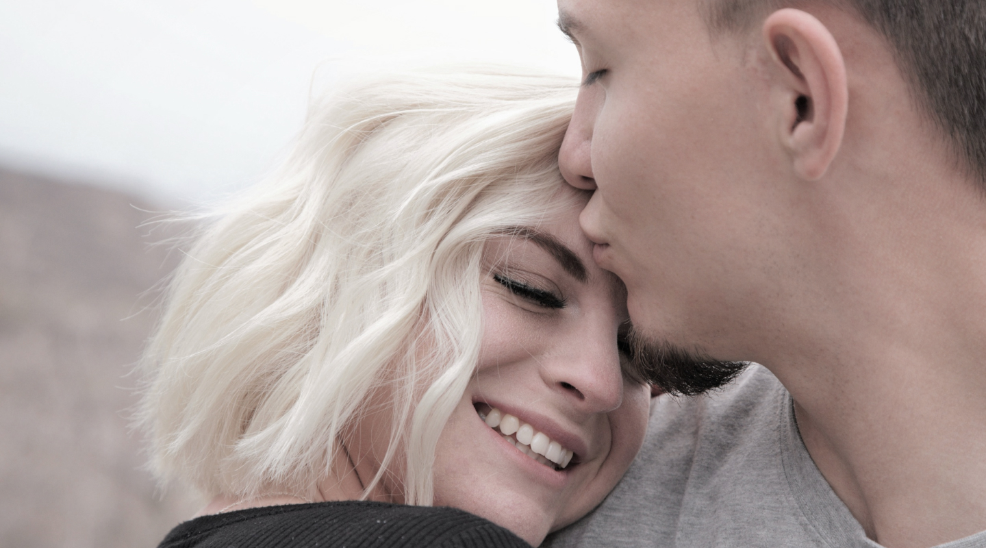 Man kissing woman on forehead