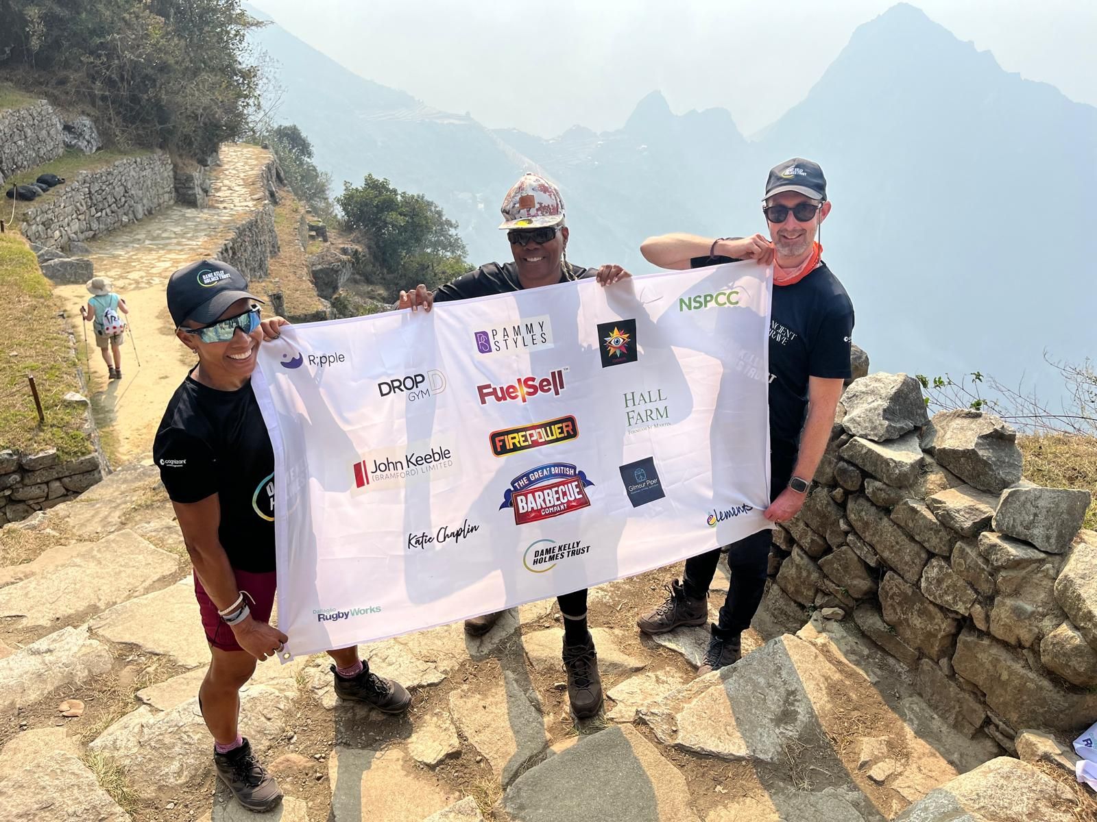 Fay Graves and friends holding a flag at Macchu Picchu