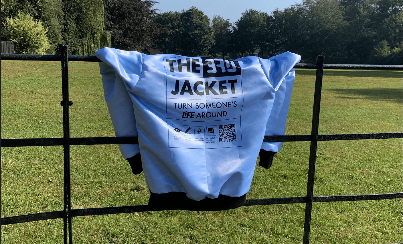 A Life Jacket with R;pple logo on a fence in a field
